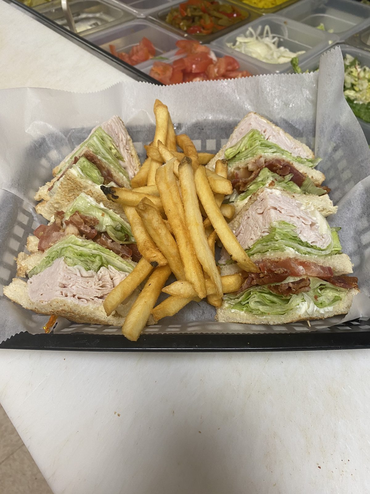 Classic turkey club sandwich with bacon, lettuce, tomato, served with fries